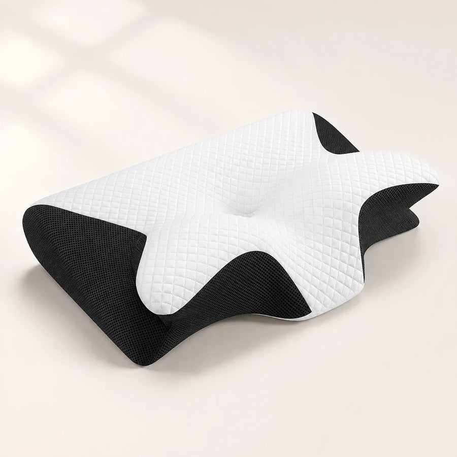 Contoured pillow with white quilted top and black mesh sides on an ivory studio background.