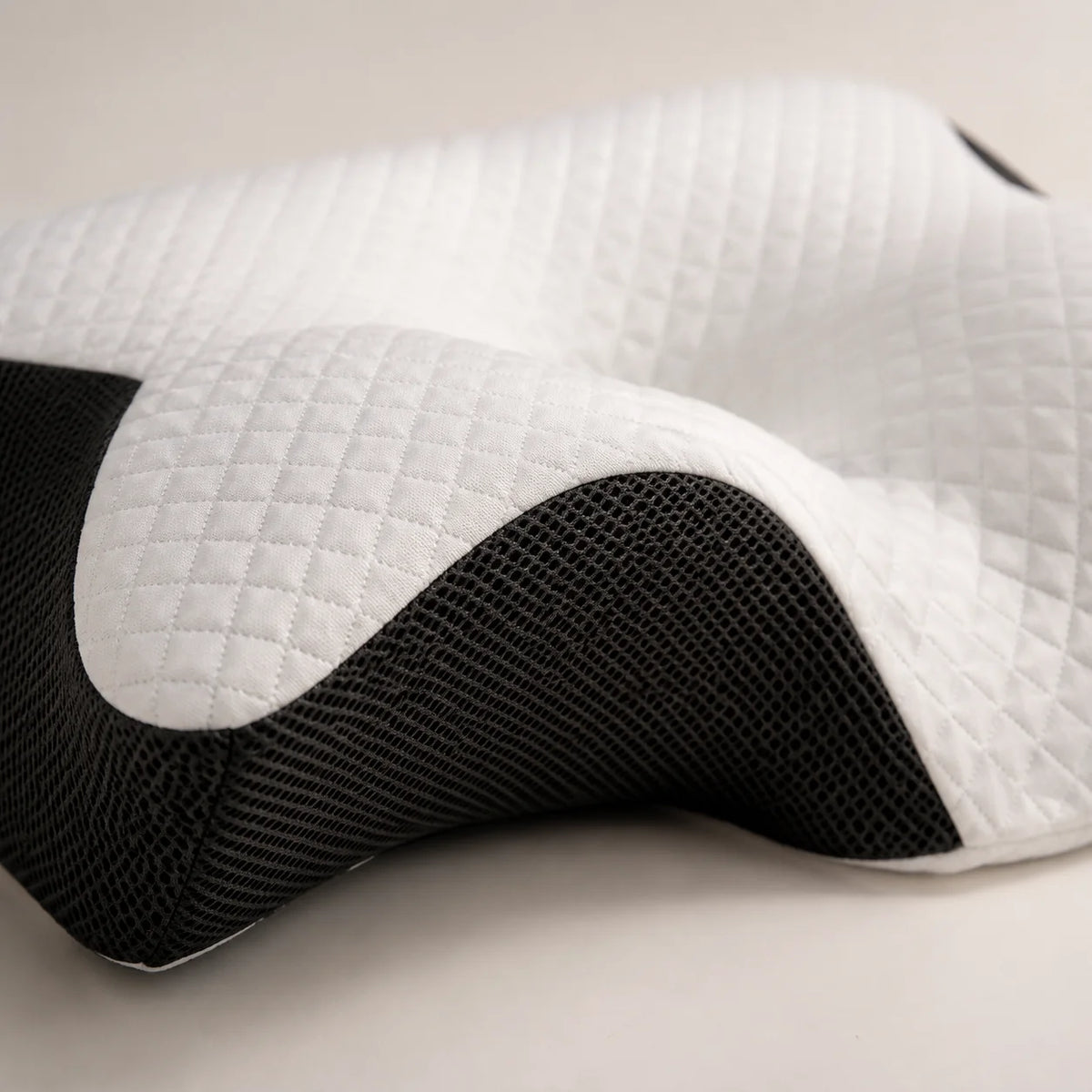 Close-up of the pillow’s white quilted cover and black mesh side panel.